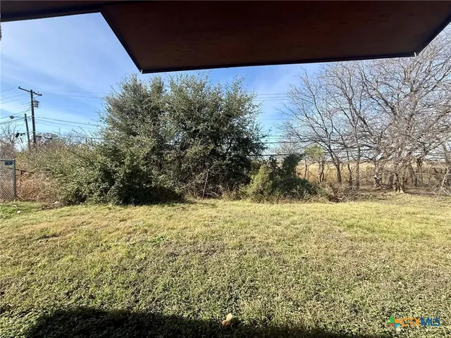 a view of large yard with large trees