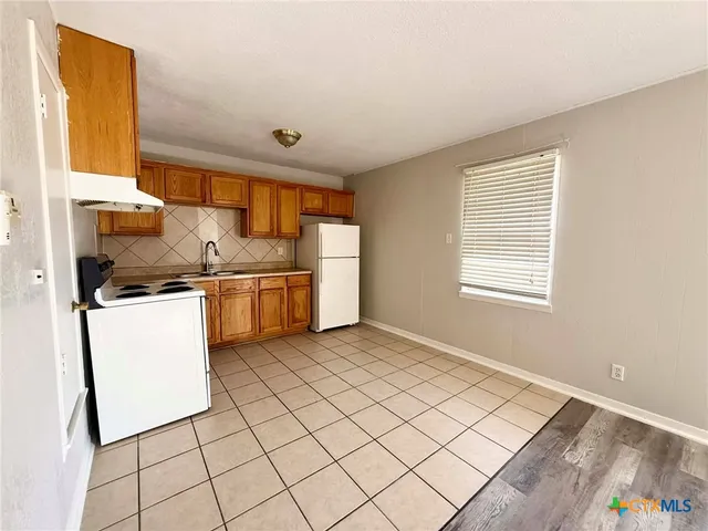 a kitchen with a stove cabinets and a refrigerator