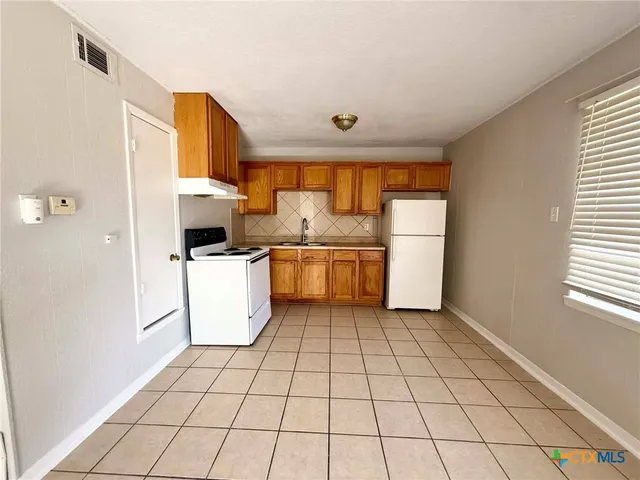 a kitchen with a stove a sink dishwasher and a refrigerator