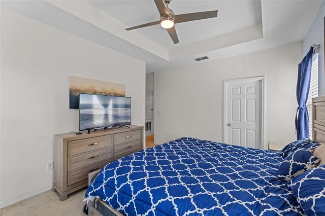 a bedroom with a bed and a flat tv screen on the dresser