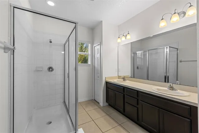 a bathroom with a double vanity sink and mirror with shower