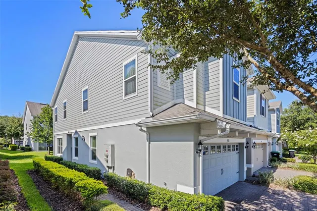 a view of a white house with a large tree and a yard