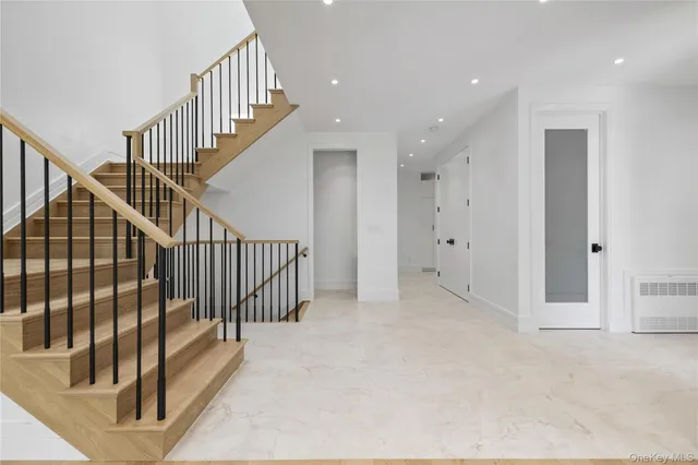 a view of staircase with railing and white walls