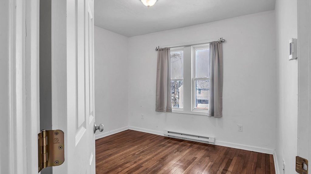 1442 Main Street, Unit 1 Worcester, MA 01603 - Photo 13 of 30 an empty room with wooden floor and windows