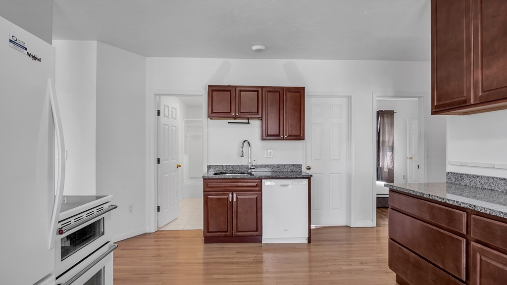 1442 Main Street, Unit 1 Worcester, MA 01603 - Photo 22 of 30 a kitchen with stainless steel appliances granite countertop a stove a sink and a refrigerator