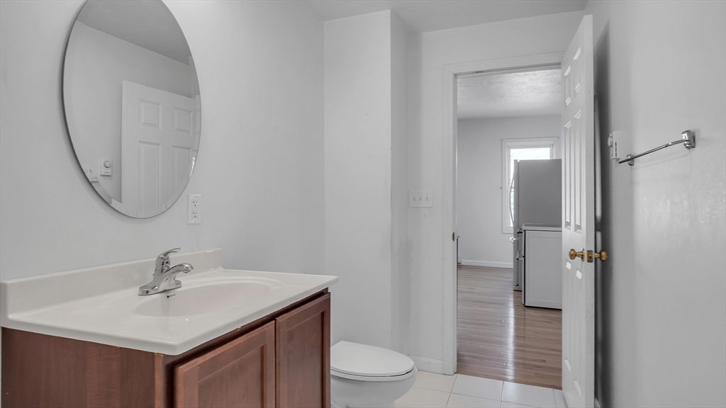 1442 Main Street, Unit 1 Worcester, MA 01603 - Photo 24 of 30 a bathroom with a sink a toilet and a mirror