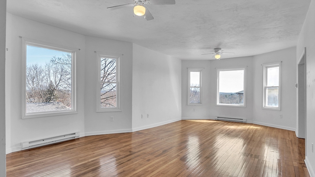 1442 Main Street, Unit 1 Worcester, MA 01603 - Photo 7 of 30 a view of an empty room with wooden floor and a window