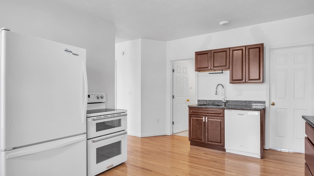 1442 Main Street, Unit 1 Worcester, MA 01603 - Photo 10 of 30 a kitchen with granite countertop a refrigerator stove and sink