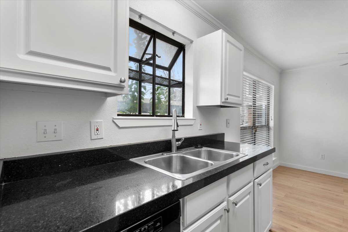 2018 West Rundberg Lane, Unit 9A Austin, TX 78758 - Photo 12 of 30 Kitchen featuring granite countertops, black electric range, microwave, updated cabinetry, bay window, dishwasher, and new refrigerator.