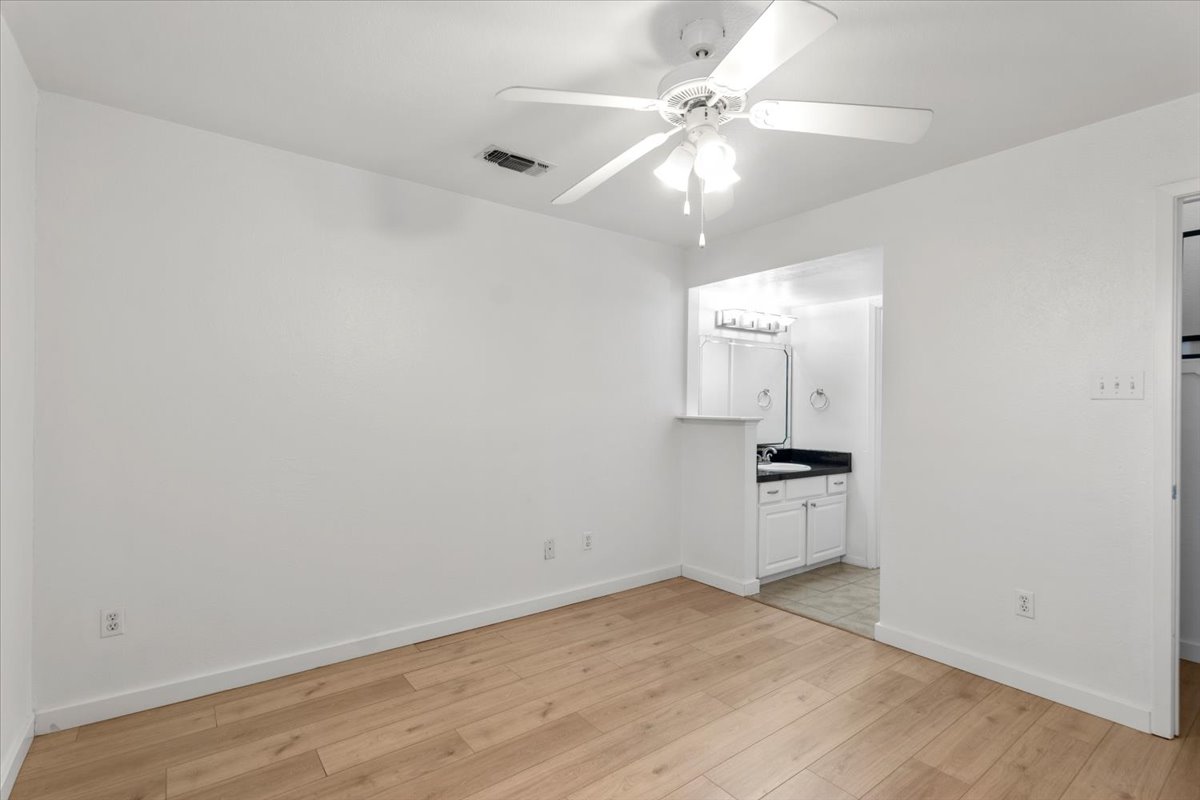 2018 West Rundberg Lane, Unit 9A Austin, TX 78758 - Photo 14 of 30 1st floor bedroom featuring a ceiling fan and new engineered wood floors, and ensuite bathroom