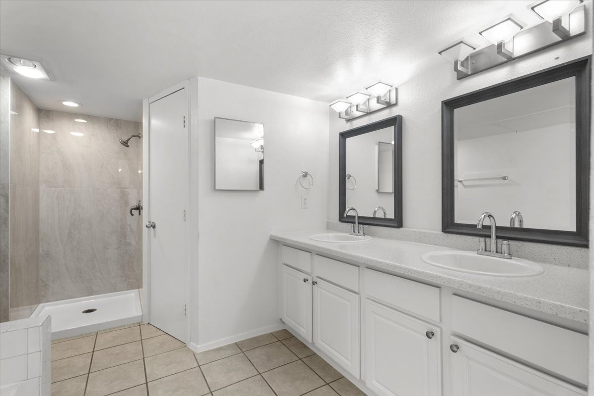 2018 West Rundberg Lane, Unit 9A Austin, TX 78758 - Photo 22 of 30 2nd floor's bathroom featuring new shower, double vanity, picture frame mirrors. Center rear door is to toilet room.