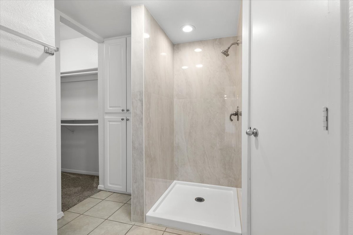 2018 West Rundberg Lane, Unit 9A Austin, TX 78758 - Photo 24 of 30 2nd floor's bathroom featuring new shower, and a walk in closet. Door to the right is toilet room.