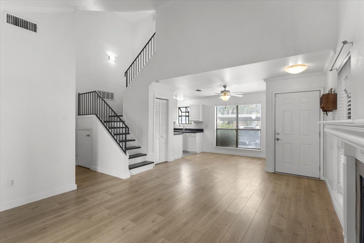 2018 West Rundberg Lane, Unit 9A Austin, TX 78758 - Photo 6 of 30 Living and dining rooms featuring light wood-style floors, lofted ceiling, a fireplace and windows on 3 sides.