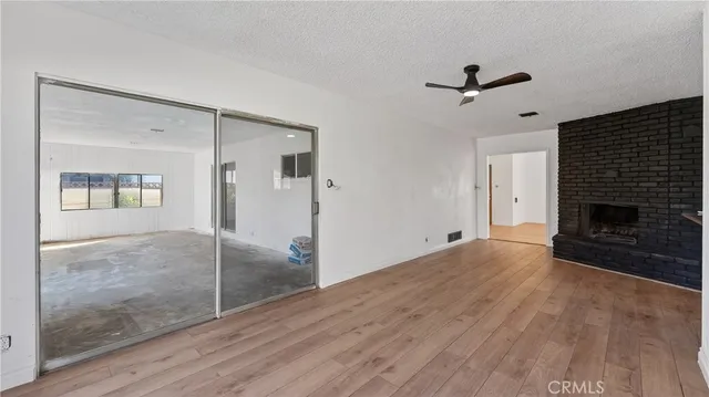 a view of an empty room with a fireplace and a window