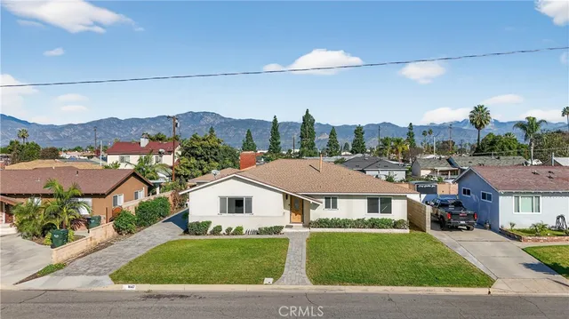 a front view of a houses with a yard and front view of a house