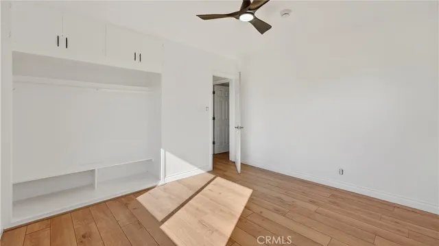 a view of a room with wooden floor and ceiling fan