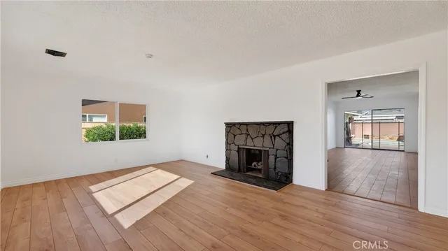 an empty room with windows and fireplace