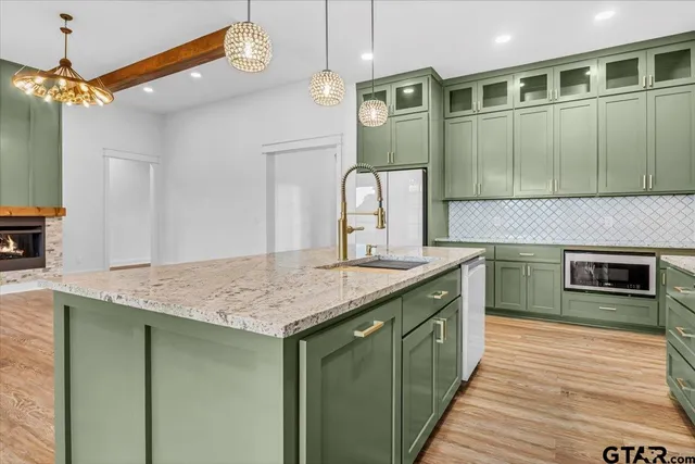 a kitchen with granite countertop cabinets a stove and a wooden floors
