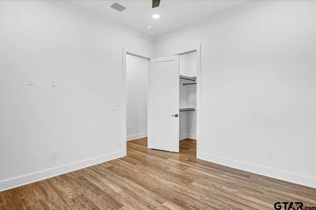 an empty room with a window and ceiling fan