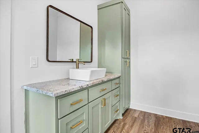 a bathroom with a granite countertop sink vanity and mirror
