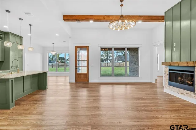 a view of a hallway with furniture and a chandelier