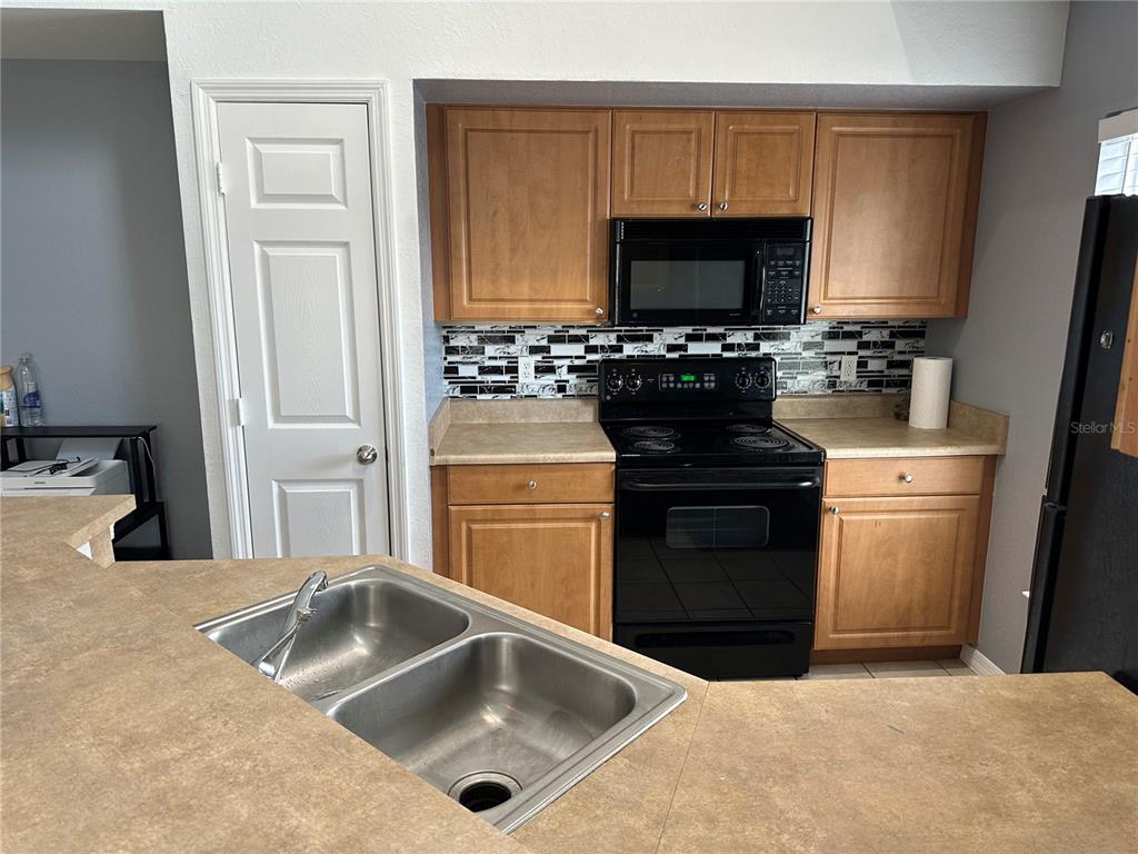 5601 Rosehill Road, Unit 201 Sarasota, FL 34233 - Photo 15 of 21 a kitchen with a sink stove and microwave