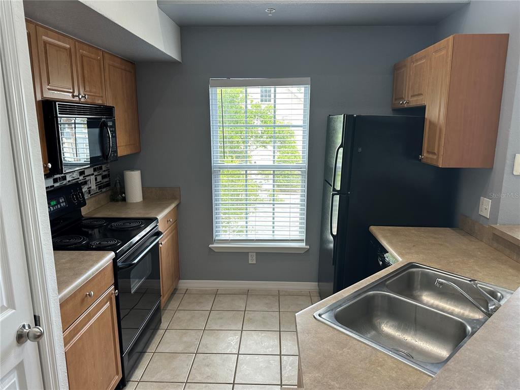 5601 Rosehill Road, Unit 201 Sarasota, FL 34233 - Photo 17 of 21 a kitchen with a sink stove and refrigerator