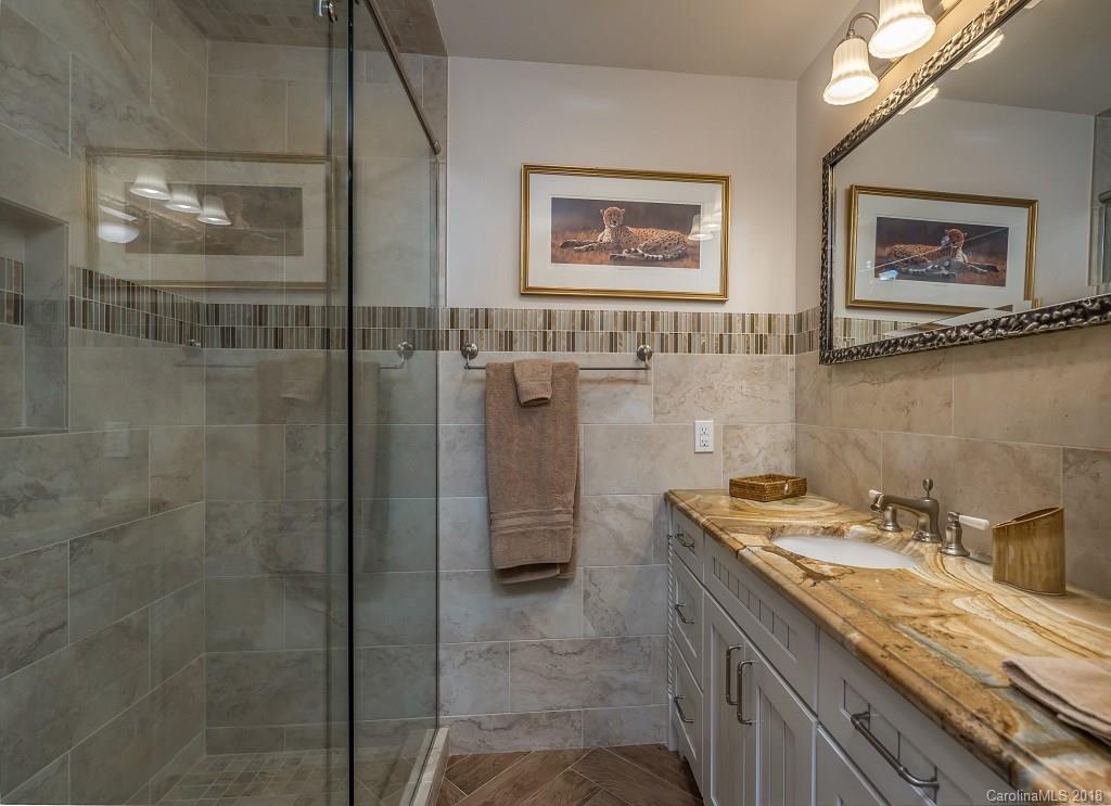44 Jervey Road, Unit 3B Tryon, NC 28782 - Photo 16 of 29 a bathroom with a granite countertop sink a mirror and a shower