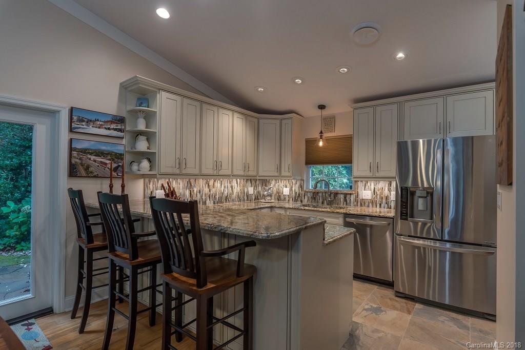44 Jervey Road, Unit 3B Tryon, NC 28782 - Photo 10 of 29 a kitchen with stainless steel appliances granite countertop a table chairs refrigerator and sink