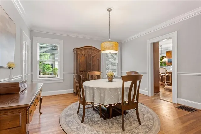 an empty room with wooden floor chandelier fan and windows
