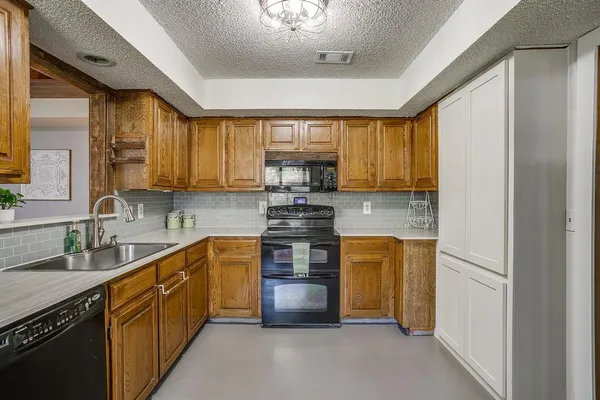 a kitchen with stainless steel appliances granite countertop a stove a sink and a refrigerator