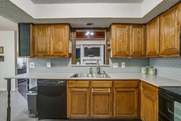 a kitchen with stainless steel appliances granite countertop a sink stove and microwave