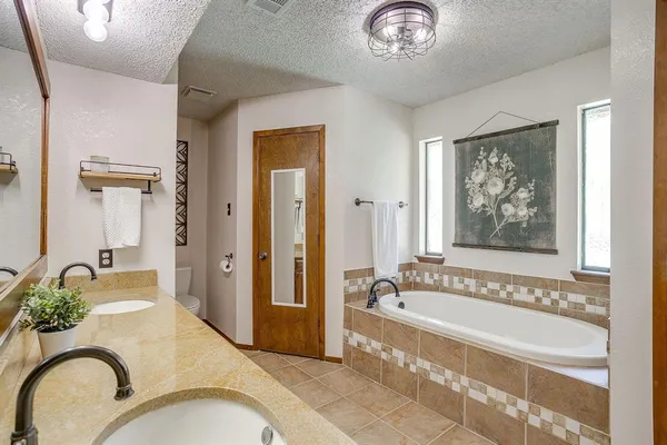 a spacious bathroom with a granite countertop tub and a mirror