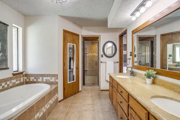 a spacious bathroom with a granite countertop tub sink and mirror