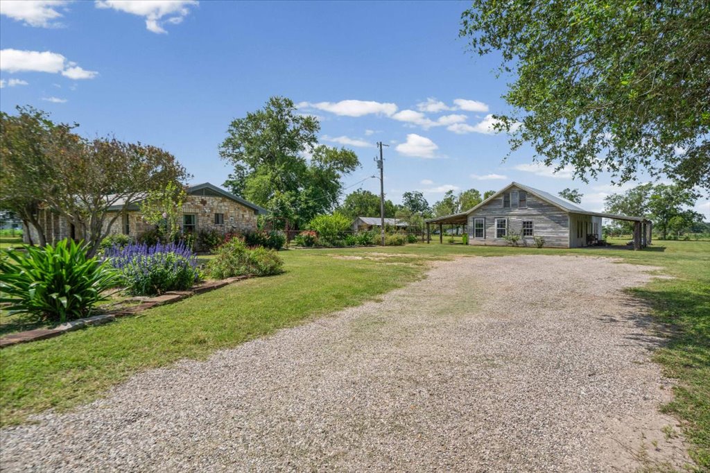 2421 Post Oak Road Webberville, TX 78653 - Photo 3 of 36 You’ve got a long gravel driveway leading up with some beautiful landscaping.