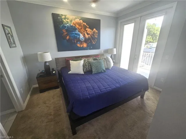 a large bed sitting in a bedroom next to a window