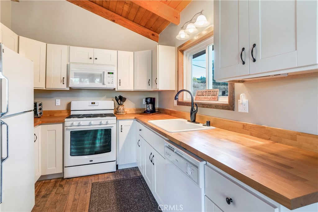 39576 Oakglen Road Fawnskin, CA 92333 - Photo 14 of 30 a kitchen with stainless steel appliances granite countertop a sink a stove and cabinets