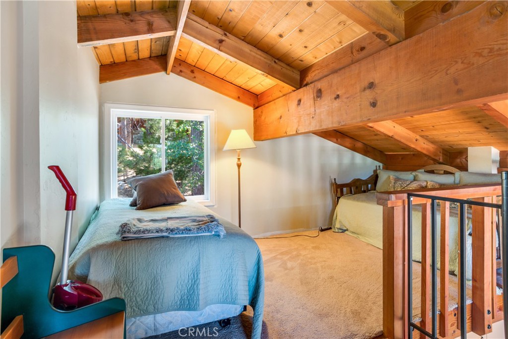 39576 Oakglen Road Fawnskin, CA 92333 - Photo 24 of 30 a bedroom with furniture and a window