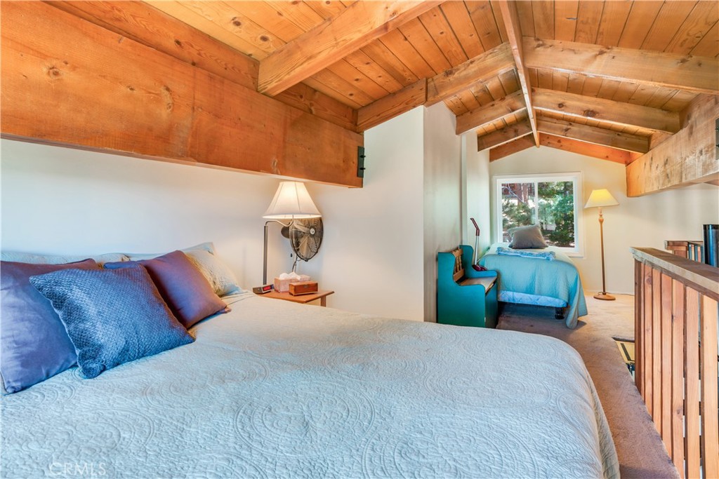 39576 Oakglen Road Fawnskin, CA 92333 - Photo 25 of 30 a bedroom with a bed and a chandelier