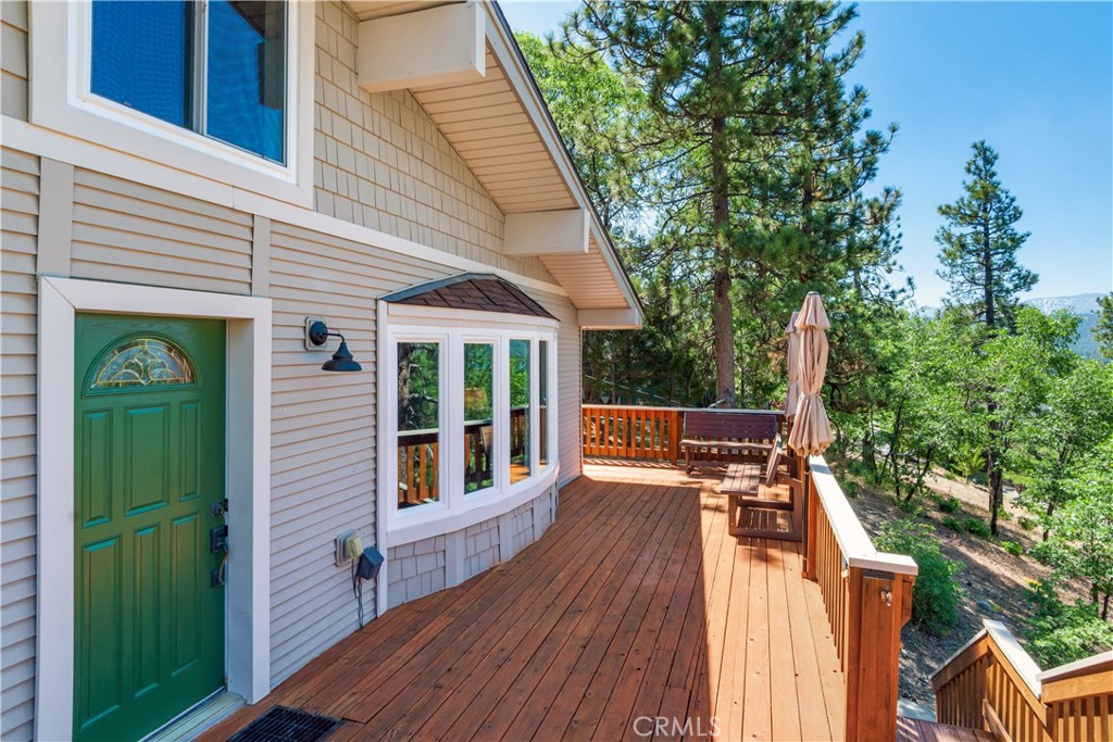 39576 Oakglen Road Fawnskin, CA 92333 - Photo 26 of 30 a view of a patio with table and chairs with wooden floor and fence