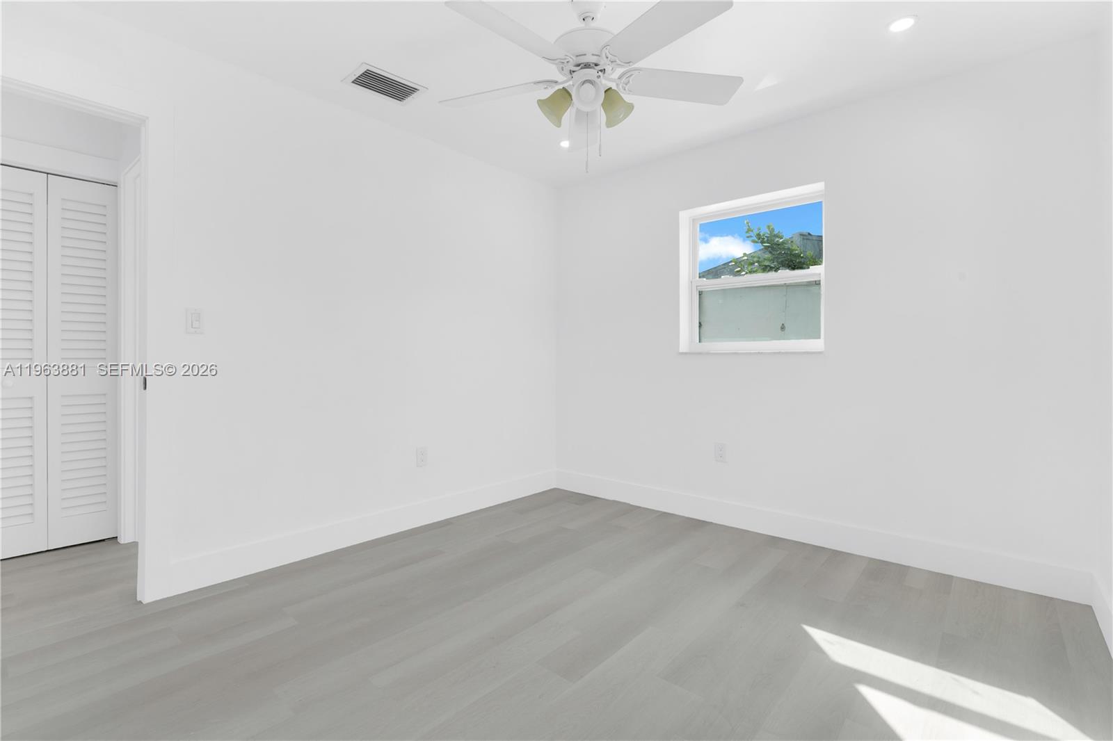 29822 Southwest 149th Avenue Homestead, FL 33033 - Photo 14 of 17 an empty room with a window and ceiling fan
