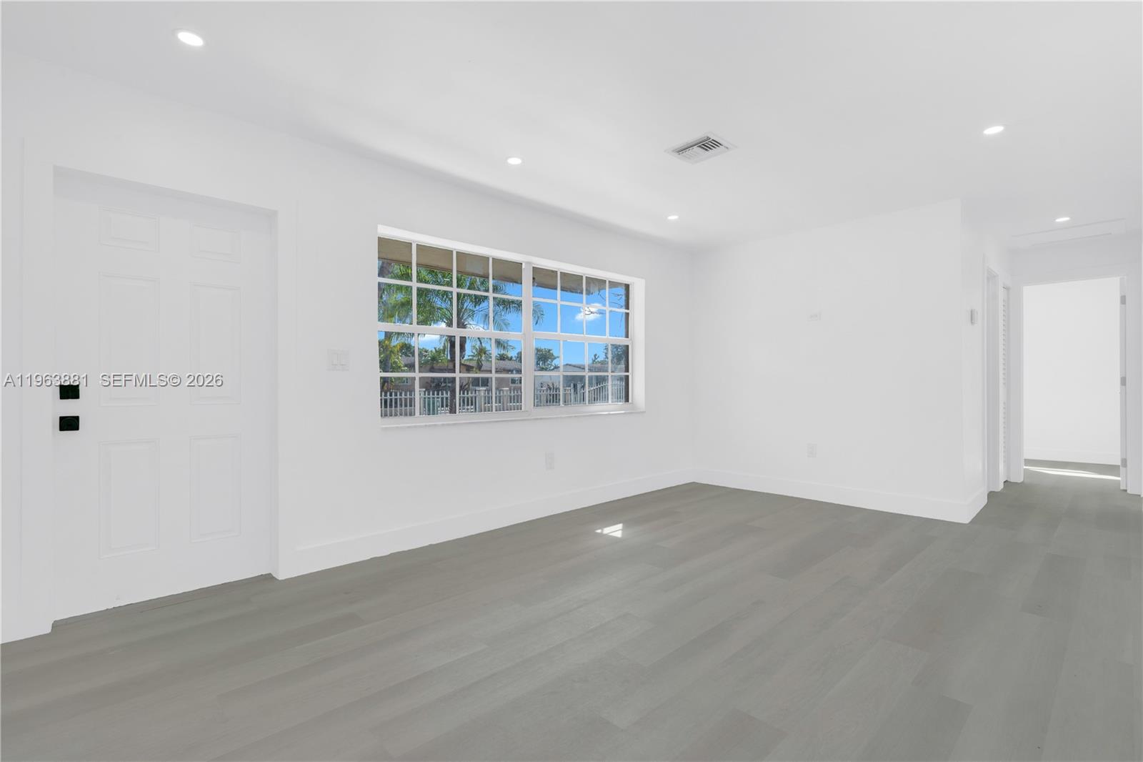 29822 Southwest 149th Avenue Homestead, FL 33033 - Photo 6 of 17 an empty room with wooden floor and windows