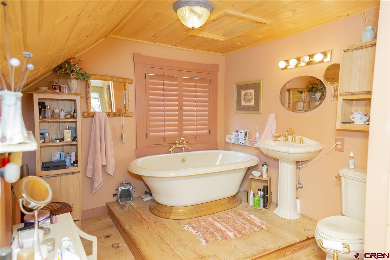 148 Rio Grande Drive Creede, CO 81130 - Photo 17 of 27 a bathroom with a sink mirror bathtub and toilet
