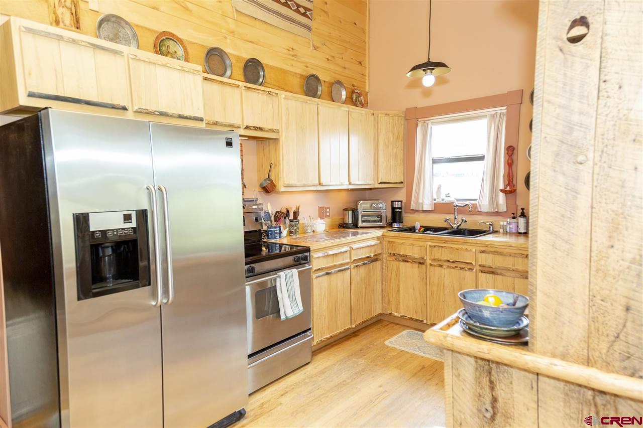 148 Rio Grande Drive Creede, CO 81130 - Photo 8 of 27 a kitchen with stainless steel appliances kitchen island granite countertop a refrigerator and a sink
