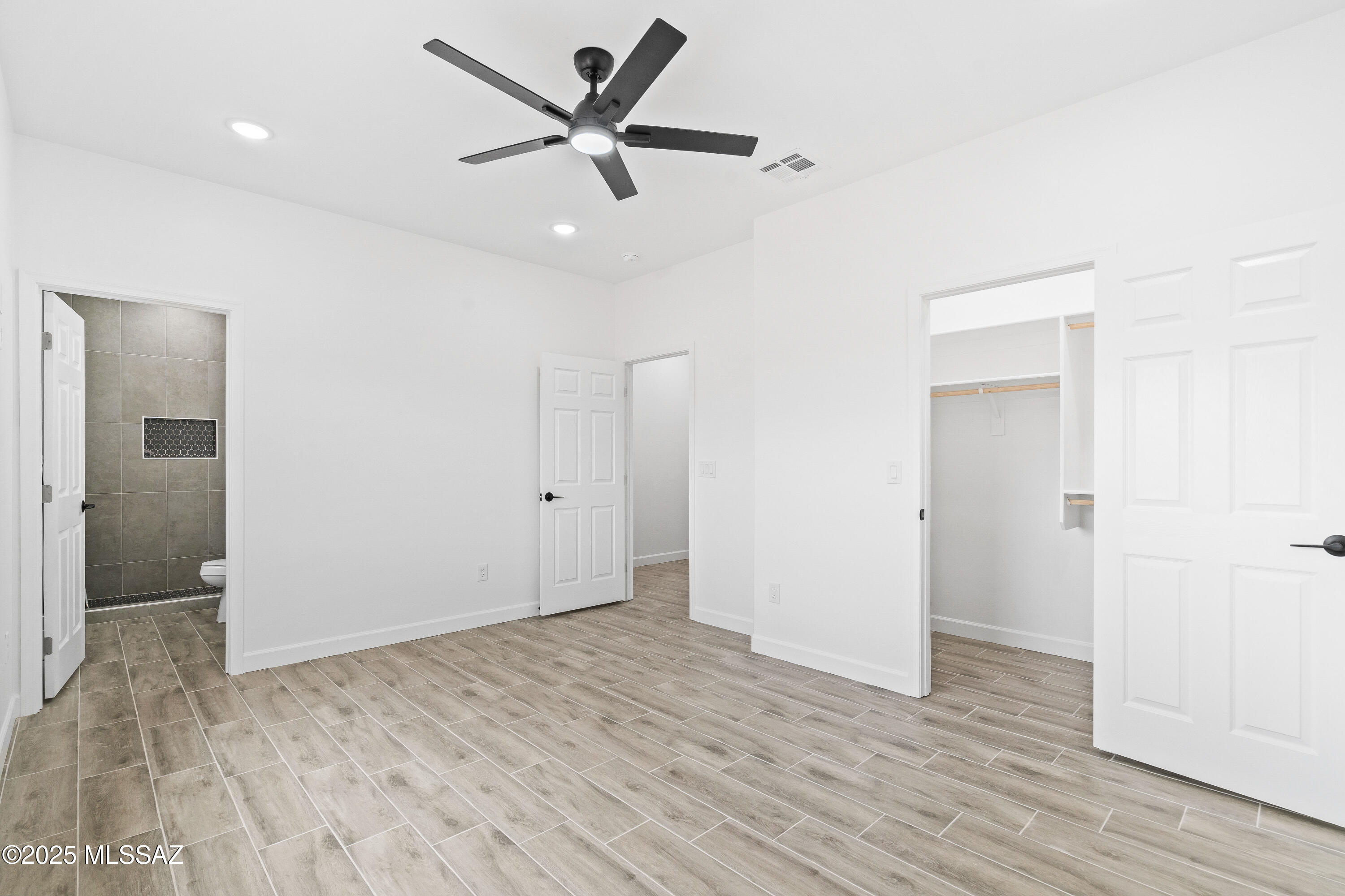 1851 Calle Salmon Rio Rico, AZ 85648 - Photo 22 of 29 an empty room with wooden floor and a ceiling fan