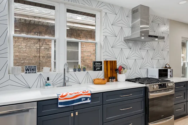 a kitchen with a sink and a stove next to a window
