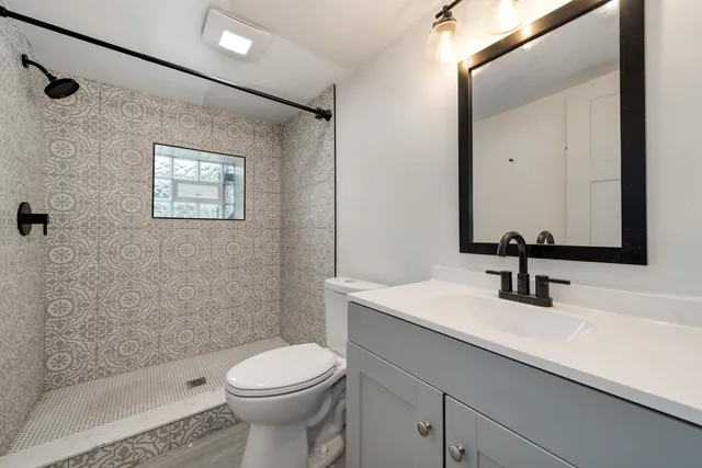 a bathroom with a sink a toilet and a mirror
