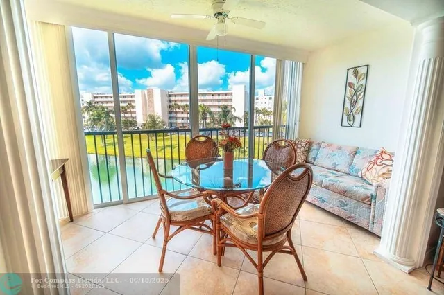 a dining room with furniture and a floor to ceiling window