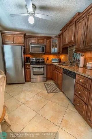 a kitchen with stainless steel appliances granite countertop a stove refrigerator sink and cabinets