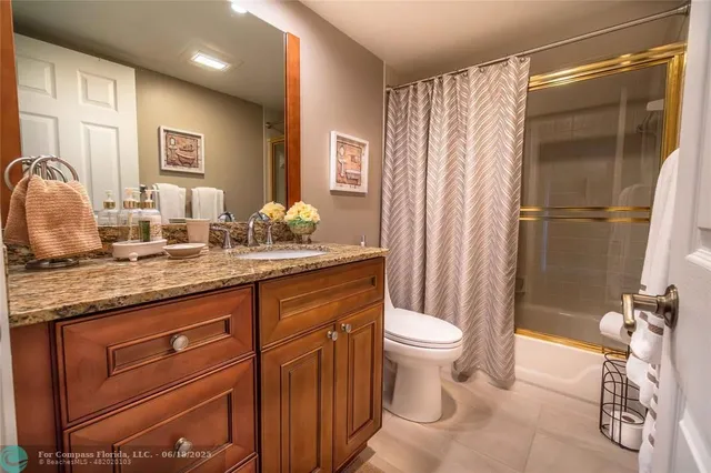 a bathroom with a granite countertop sink toilet and shower